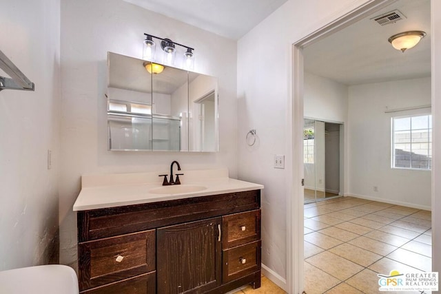 bathroom with tile patterned floors, vanity, and an enclosed shower