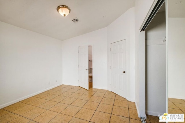 unfurnished bedroom with light tile patterned floors and a closet