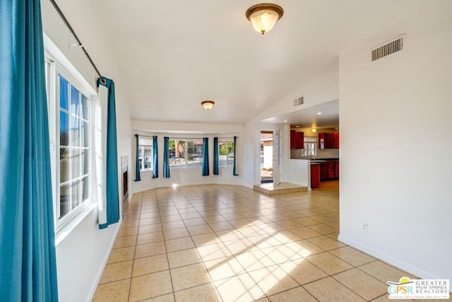 unfurnished living room featuring light tile patterned floors and vaulted ceiling