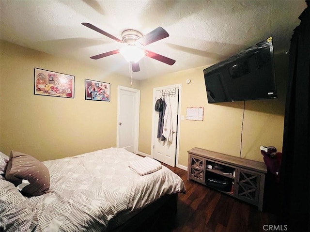 bedroom featuring a textured ceiling, ceiling fan, a closet, and dark hardwood / wood-style floors