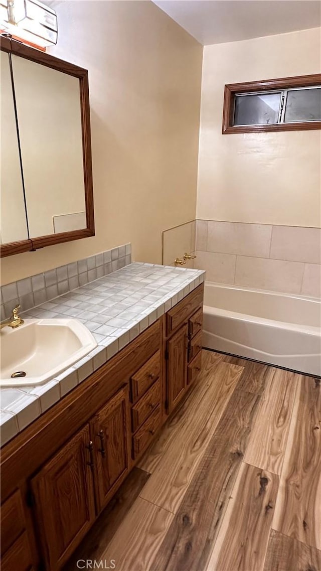 bathroom with vanity, a bath, a wall mounted air conditioner, and hardwood / wood-style flooring