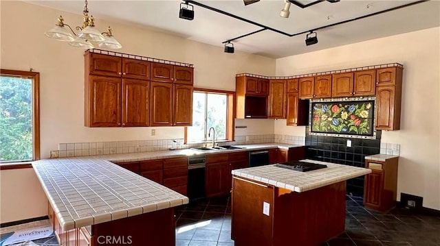 kitchen featuring tile counters, a center island, sink, and hanging light fixtures