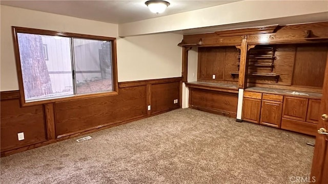 bar featuring light colored carpet and wood walls