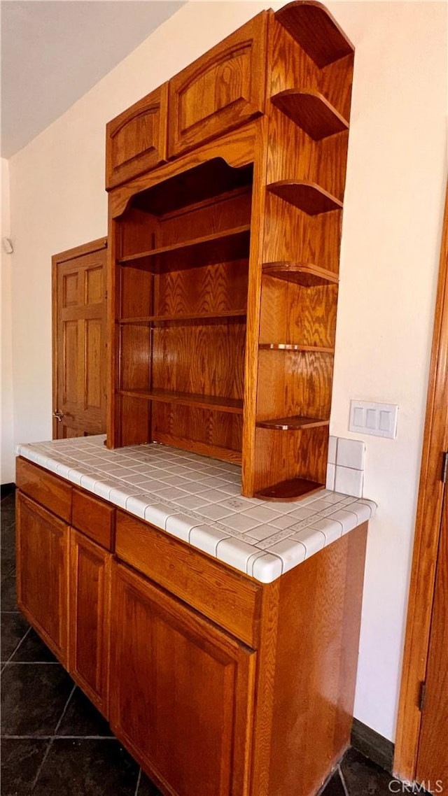 bar featuring tile countertops and dark tile patterned flooring