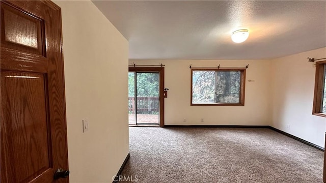 carpeted empty room featuring a textured ceiling