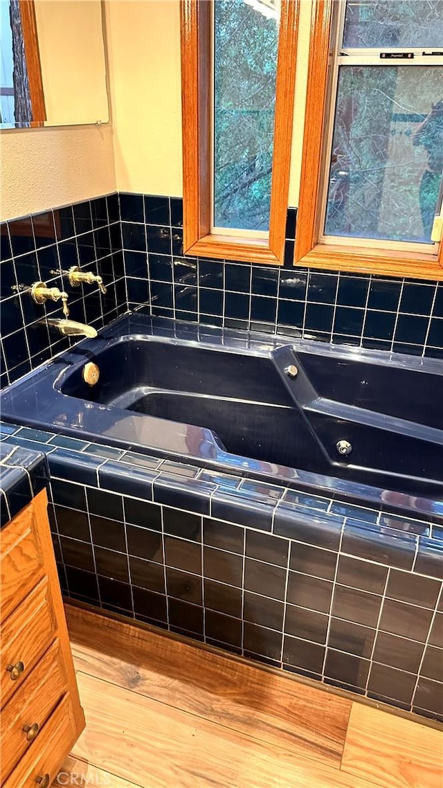 bathroom featuring a tub to relax in and hardwood / wood-style flooring