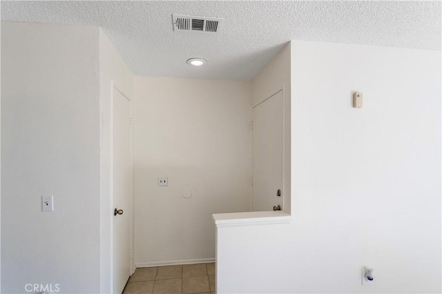 laundry room with light tile patterned floors and a textured ceiling