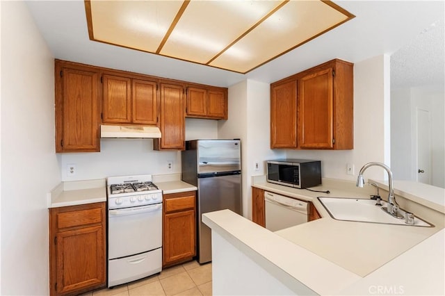 kitchen with kitchen peninsula, appliances with stainless steel finishes, light tile patterned floors, and sink