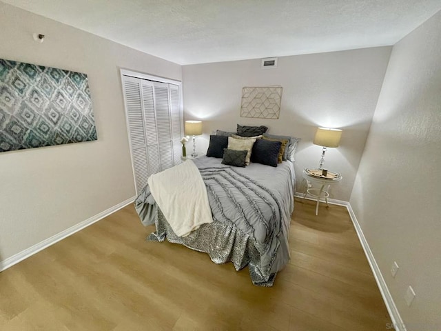 bedroom with wood-type flooring and a closet