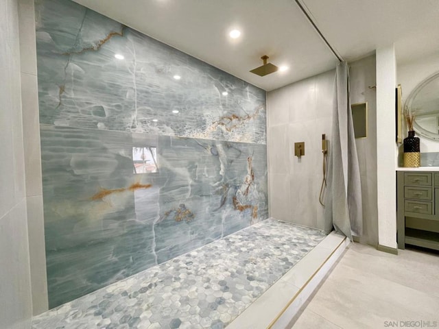 bathroom with vanity, walk in shower, and tile walls