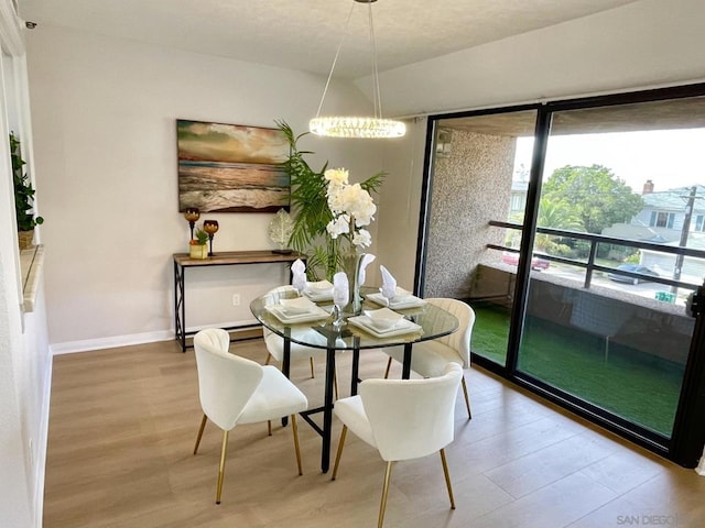 dining room featuring wood-type flooring and an inviting chandelier