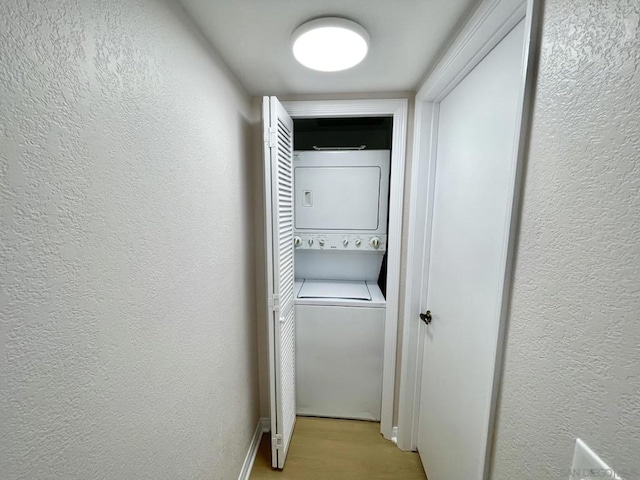 washroom featuring light wood-type flooring and stacked washer / dryer