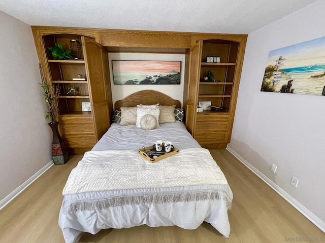 bedroom featuring light hardwood / wood-style flooring and a textured ceiling