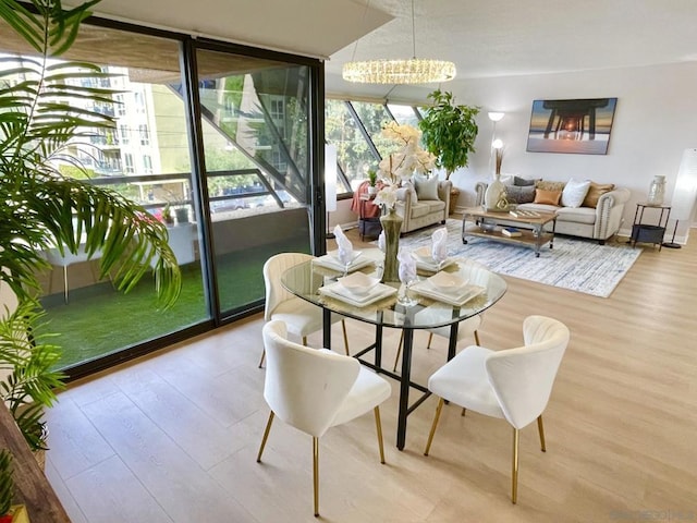 dining area featuring a notable chandelier and light hardwood / wood-style flooring