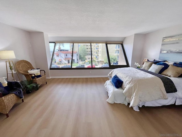 bedroom with a textured ceiling and light hardwood / wood-style floors