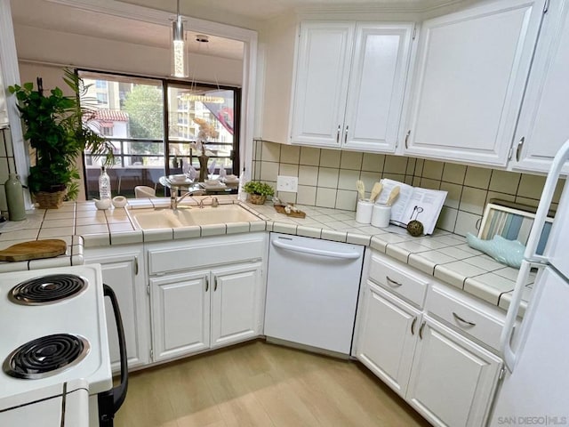 kitchen with white cabinets, white appliances, tile countertops, and light hardwood / wood-style floors