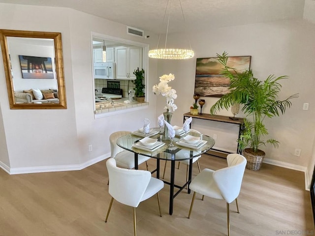 dining room featuring light hardwood / wood-style floors and a notable chandelier