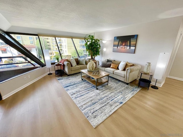 living room with wood-type flooring, a textured ceiling, and a wealth of natural light