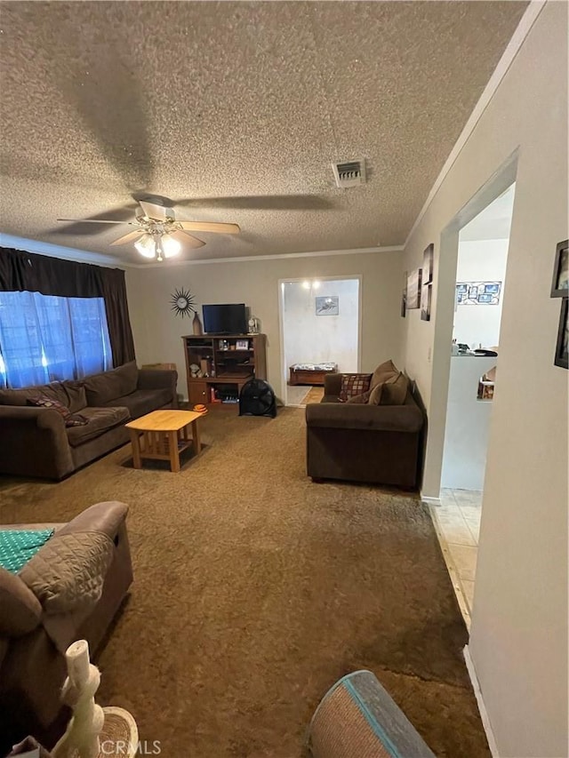 living room featuring ceiling fan, a textured ceiling, carpet, and crown molding