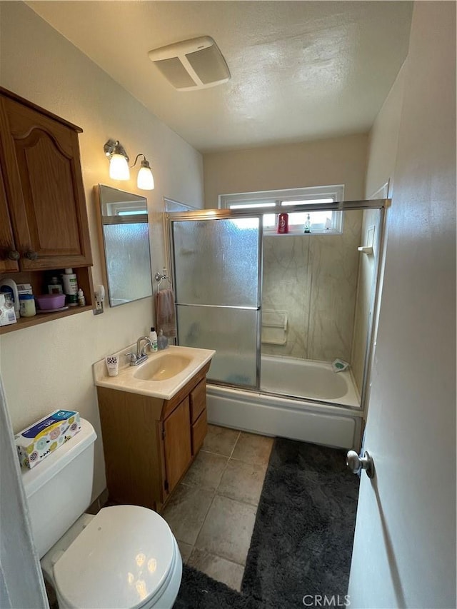 full bathroom with tile patterned floors, bath / shower combo with glass door, toilet, and vanity