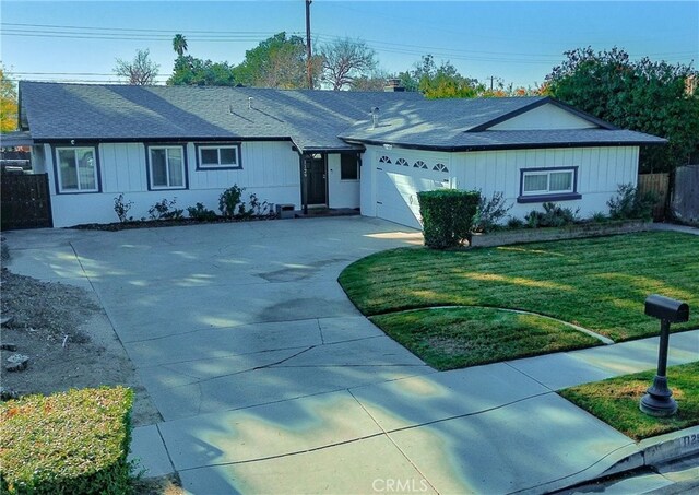 ranch-style home featuring a front lawn and a garage