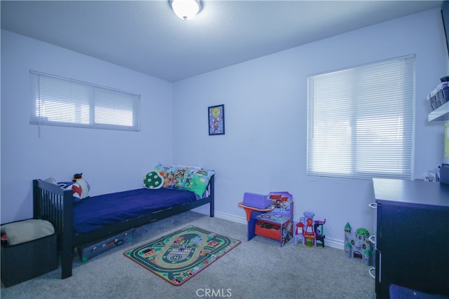 bedroom featuring multiple windows and carpet flooring