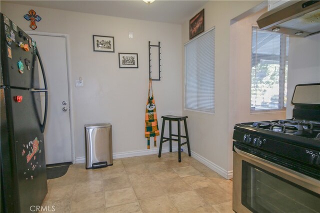 kitchen featuring refrigerator and black gas range