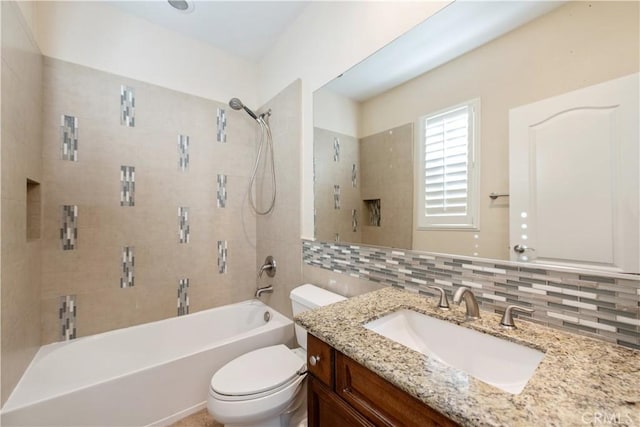 full bathroom with vanity, tiled shower / bath combo, toilet, tile walls, and tasteful backsplash