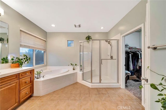 bathroom featuring tile patterned floors, plus walk in shower, and vanity