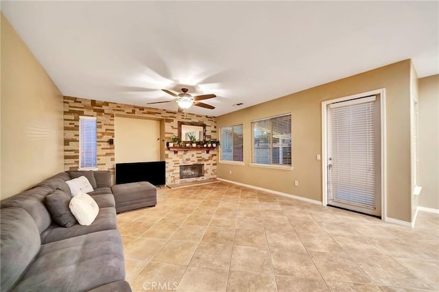 living room featuring a fireplace, ceiling fan, and light tile patterned flooring