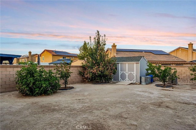 yard at dusk featuring a storage unit