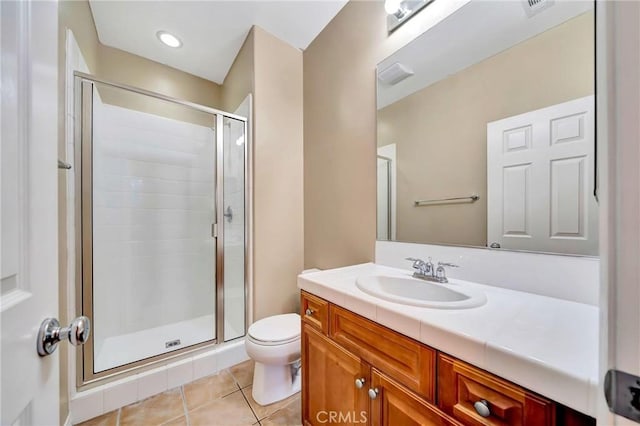 bathroom with tile patterned floors, walk in shower, vanity, and toilet