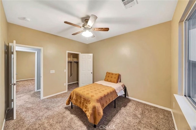 carpeted bedroom with ceiling fan, a spacious closet, and a closet