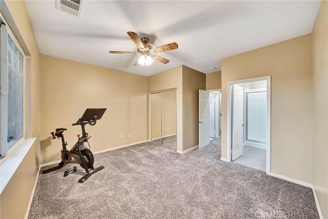 exercise area featuring ceiling fan and light colored carpet