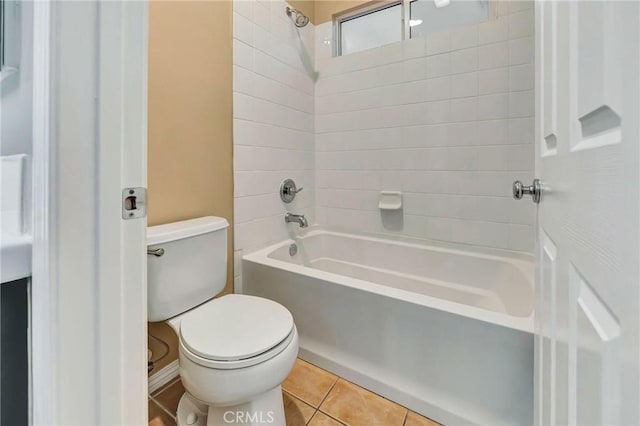 bathroom with tile patterned flooring, toilet, and tiled shower / bath