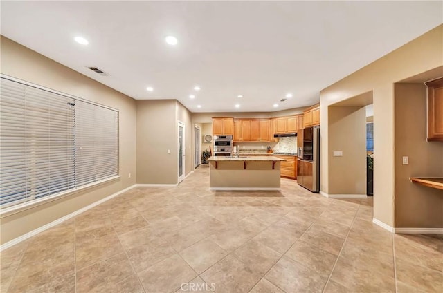 kitchen featuring a center island with sink, sink, light tile patterned floors, appliances with stainless steel finishes, and tasteful backsplash