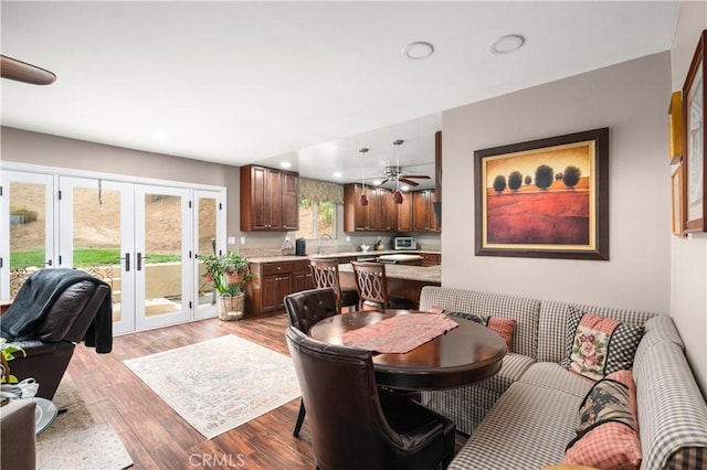 dining space featuring french doors, sink, and light hardwood / wood-style flooring