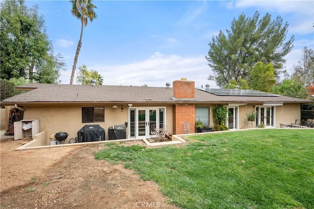 back of house featuring a yard, french doors, and solar panels