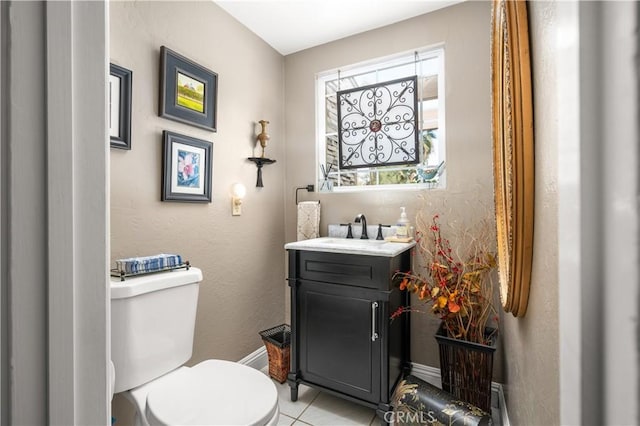 bathroom with toilet, tile patterned floors, and vanity