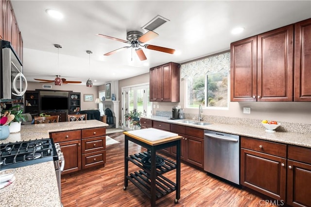 kitchen with ceiling fan, appliances with stainless steel finishes, wood-type flooring, and sink