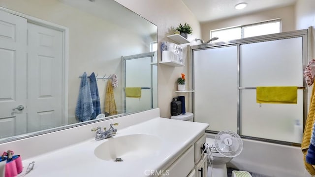 full bathroom with vanity, bath / shower combo with glass door, and toilet