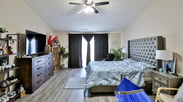 bedroom with ceiling fan, light hardwood / wood-style flooring, and vaulted ceiling