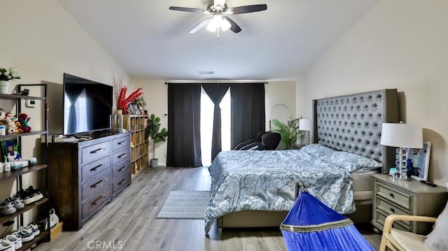 bedroom featuring ceiling fan, light hardwood / wood-style floors, and vaulted ceiling