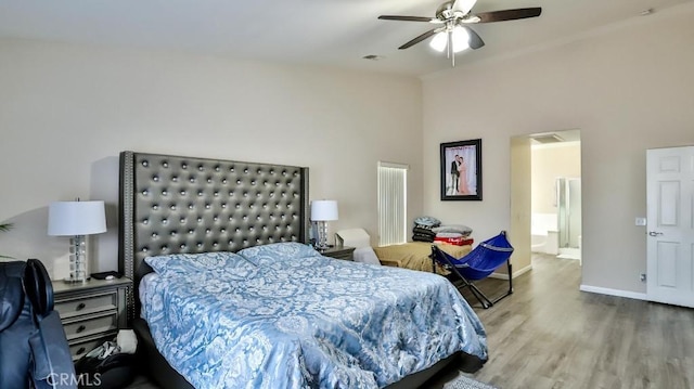 bedroom with a towering ceiling, hardwood / wood-style flooring, and ceiling fan