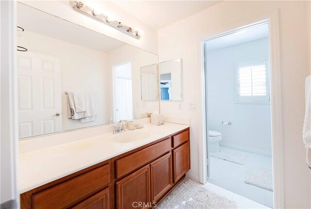 bathroom featuring tile patterned flooring, vanity, and toilet