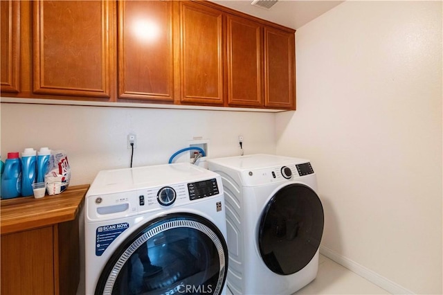 laundry room featuring cabinets and washer and clothes dryer