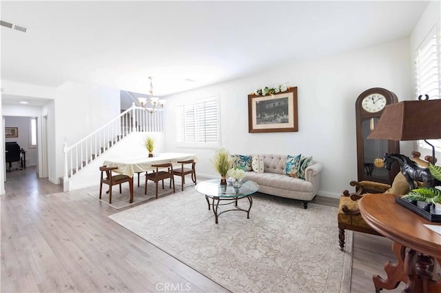 living room featuring light hardwood / wood-style flooring and a notable chandelier