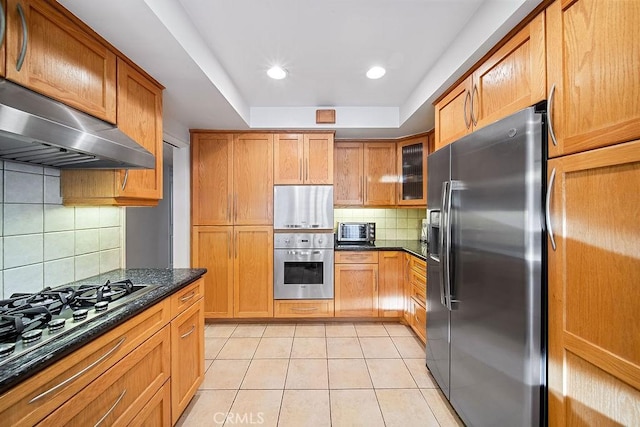 kitchen with tasteful backsplash, stainless steel fridge with ice dispenser, dark stone countertops, black gas stovetop, and exhaust hood