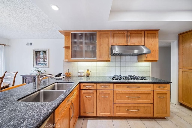 kitchen featuring sink, stainless steel gas cooktop, tasteful backsplash, extractor fan, and light tile patterned flooring