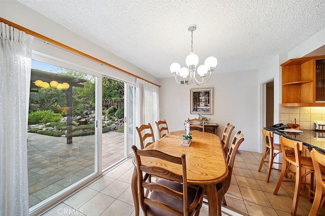 tiled dining area featuring a textured ceiling and an inviting chandelier